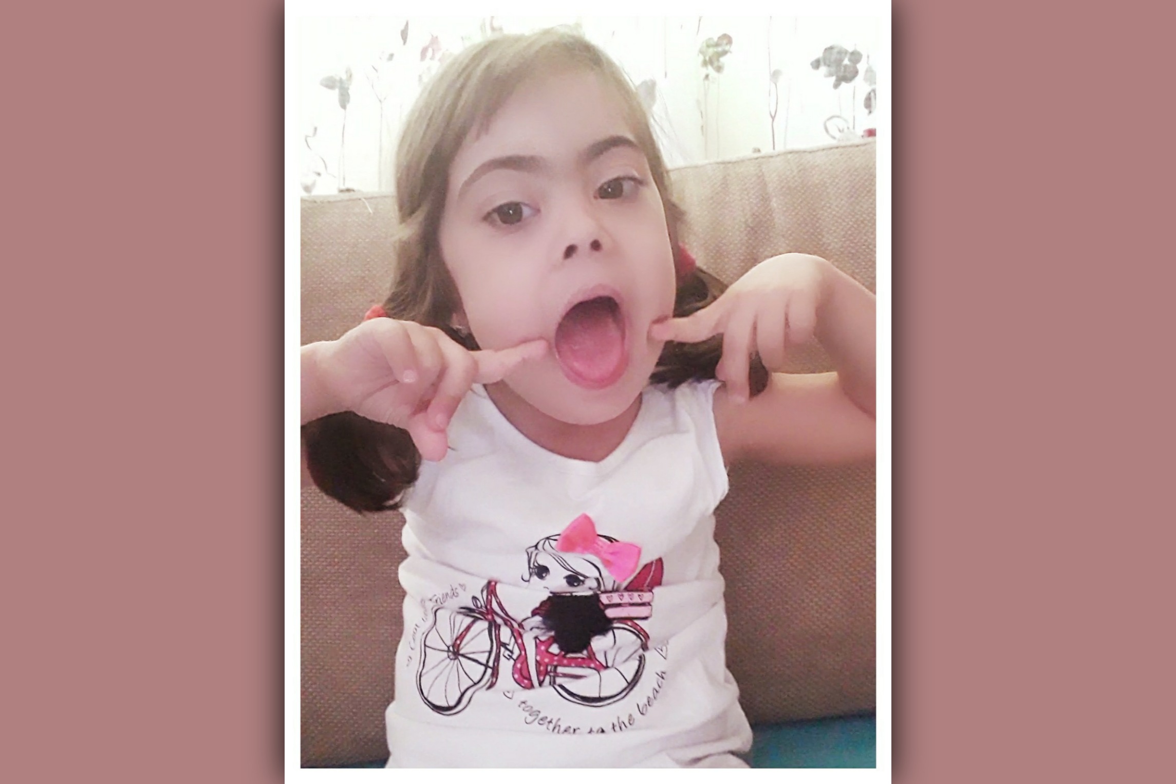 imagen nina sindrome de down señalando su boca