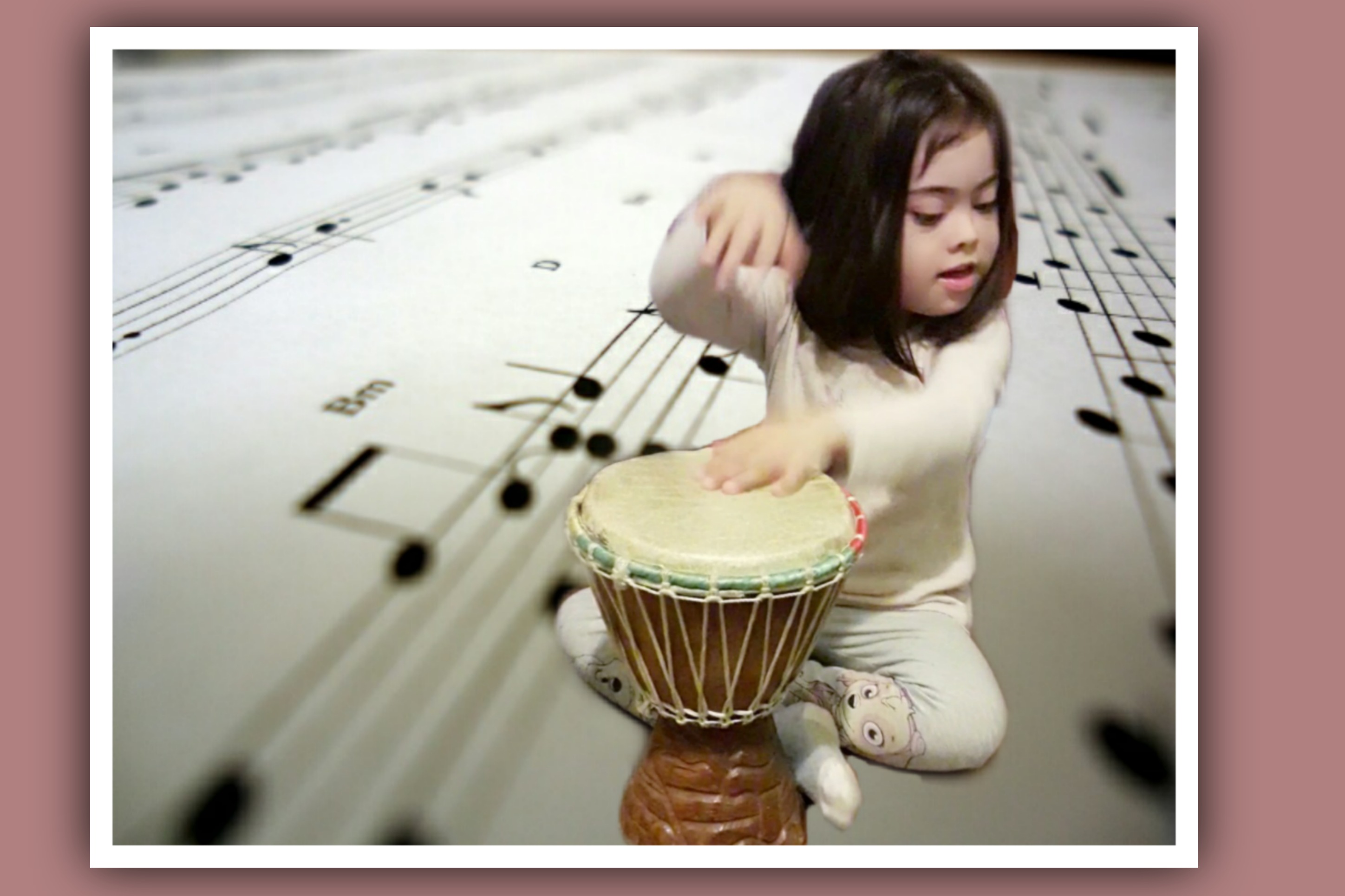 nina con sindrome de down tocando un djembe