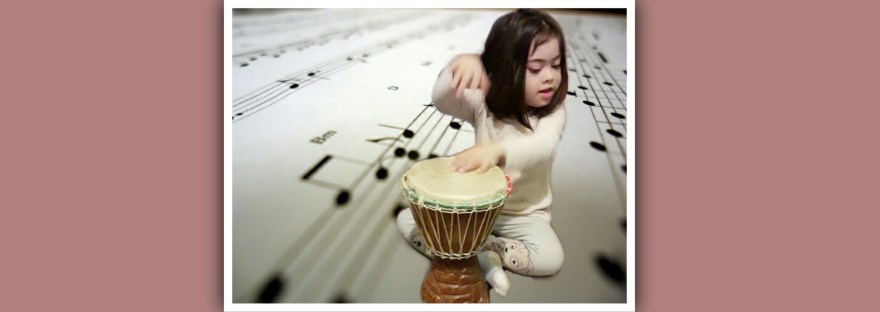 nina con sindrome de down tocando un djembe
