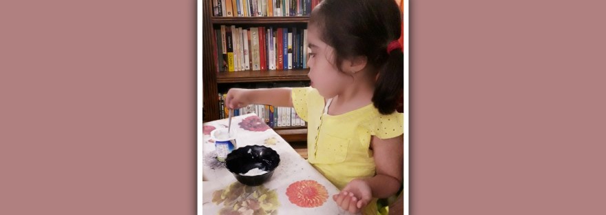 niña sindrome de down trasvasando un yogur