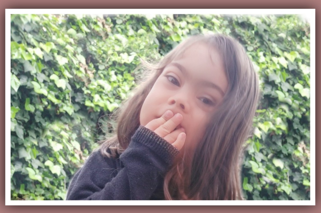 imagen de niña con sindrome de down tapandose la boca