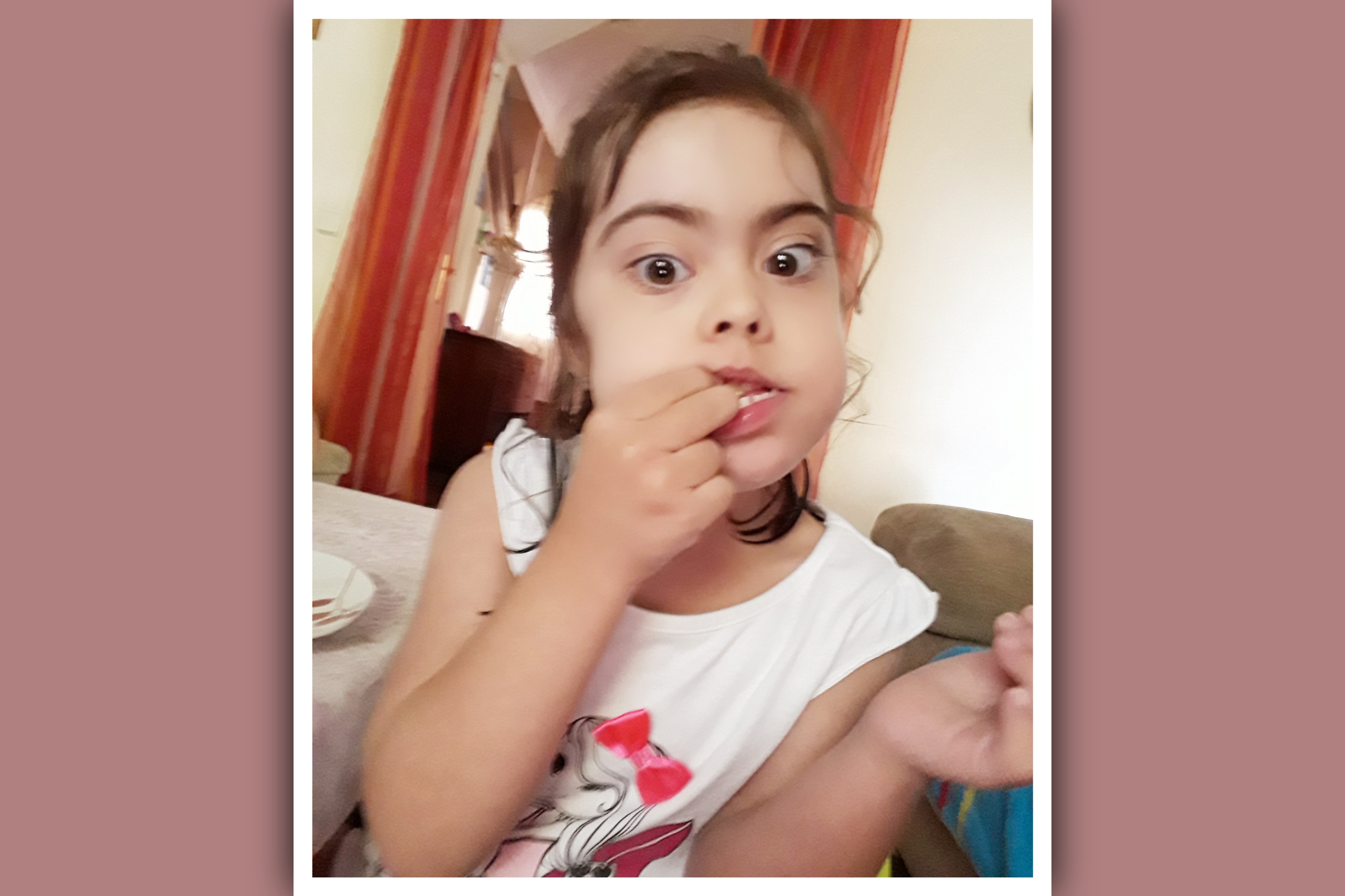 niña con sindrome de down comiendo
