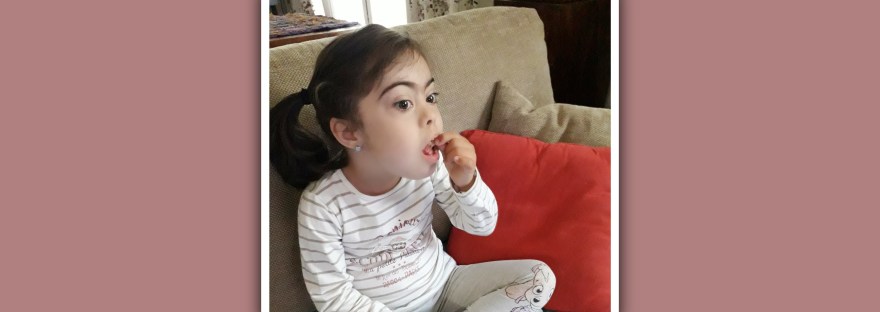 niña con sindrome de down comiendo