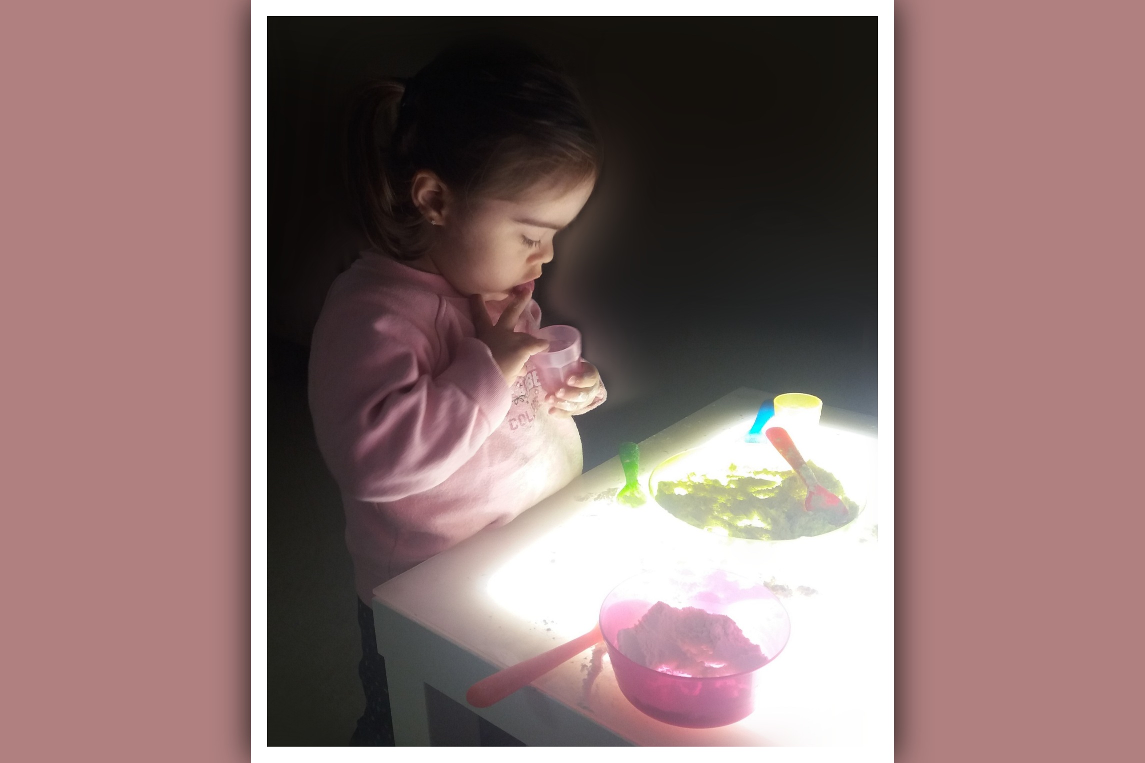 niña con sindrome de down explorando en una mesa de luz