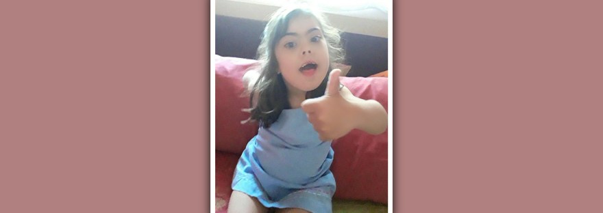 imagen de niña con sindrome de down con el pulgar hacia arriba