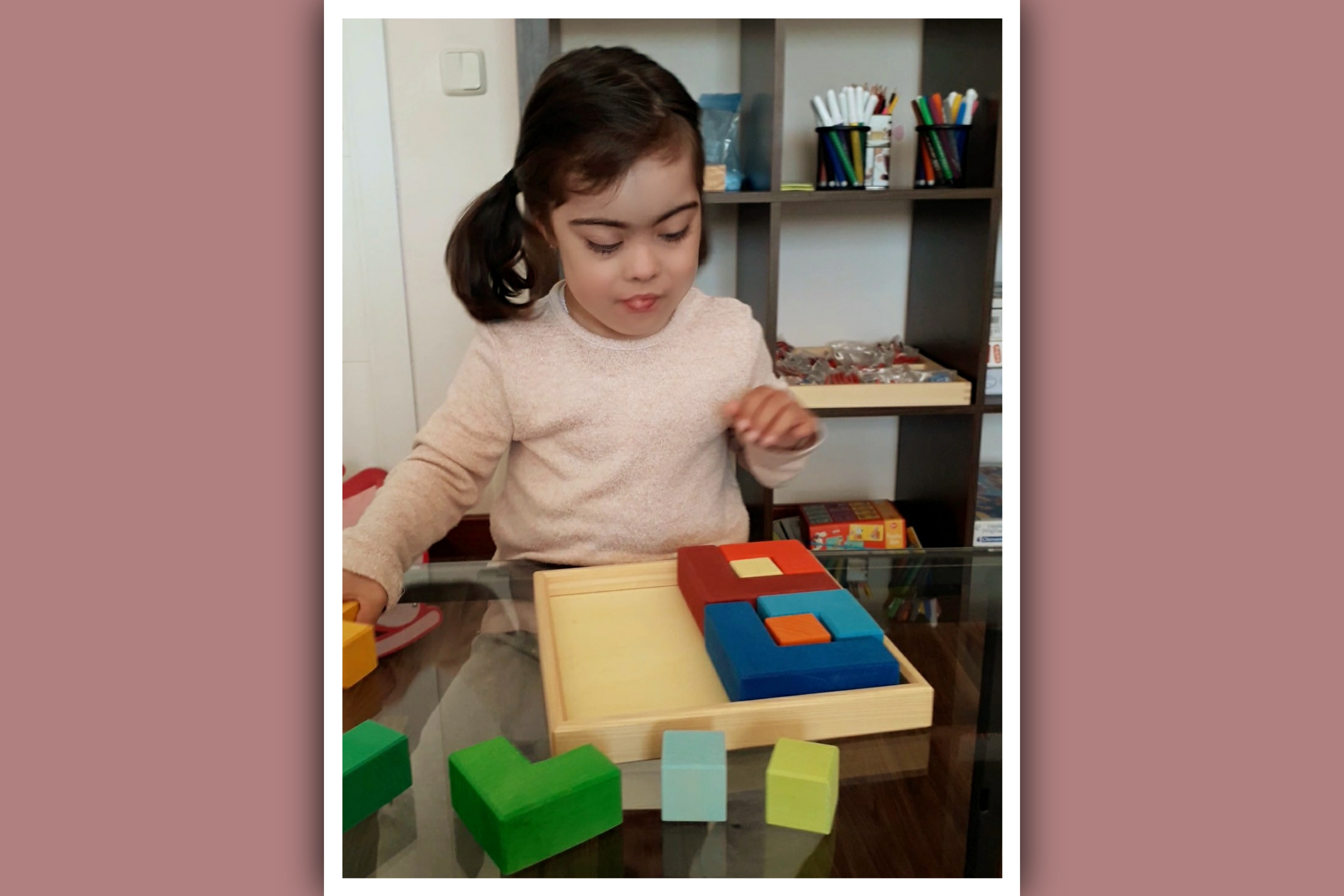 imagen de niña con sindrome de down haciendo un puzzle cromatico grimm