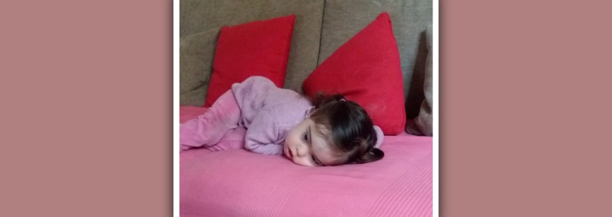 imagen nina con sindrome de down triste en el sofa