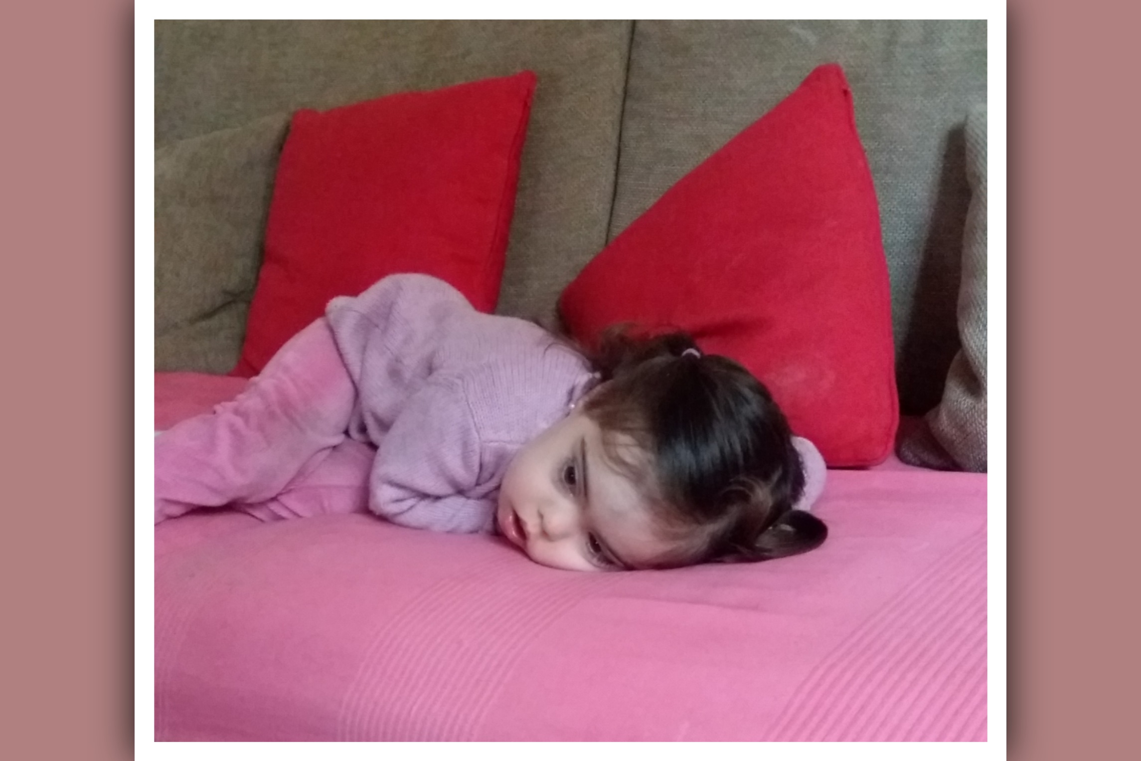 imagen nina con sindrome de down triste tumbada en el sofa
