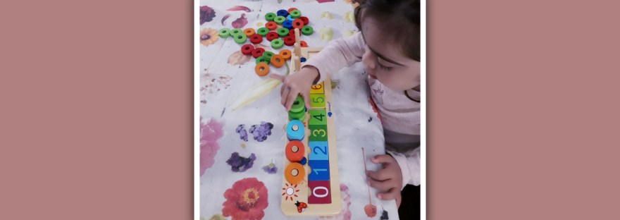 imagen nina con sindrome de down jugando con matematicas montessori