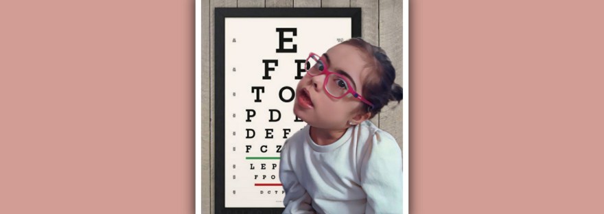 imagen niña sindrome down con gafas y tablero de letras optica