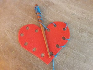 imagen de fieltro con agujeros para coser, aguja de madera e hilo