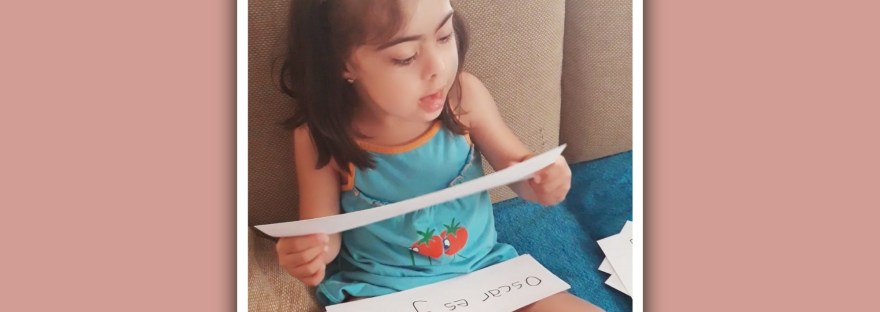 imagen niña con sindrome de down leyendo tarjetas con palabras